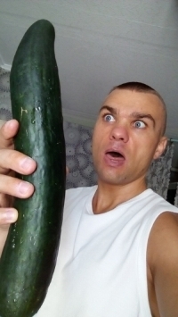 Man met een enorme komkommer